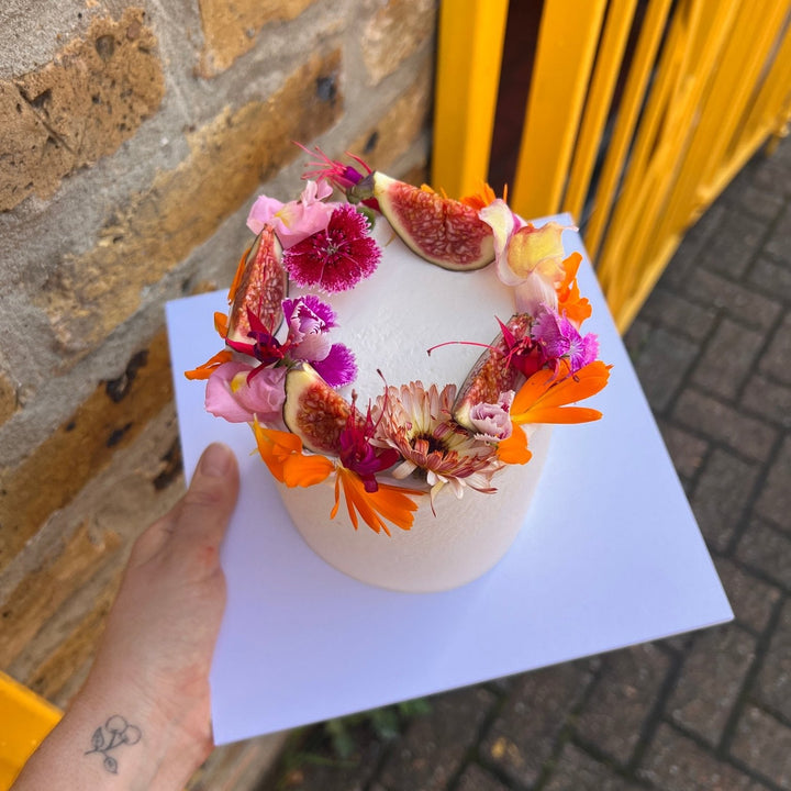 Vanilla & raspberry cake decorated with figs and fresh edible flowers, London